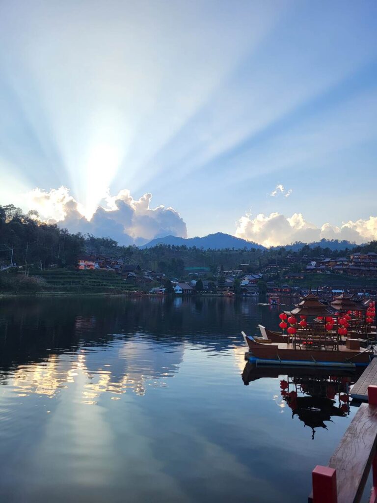 Ban Rak Thai Village in Thailand with the sun poking over the surrounding mountains
