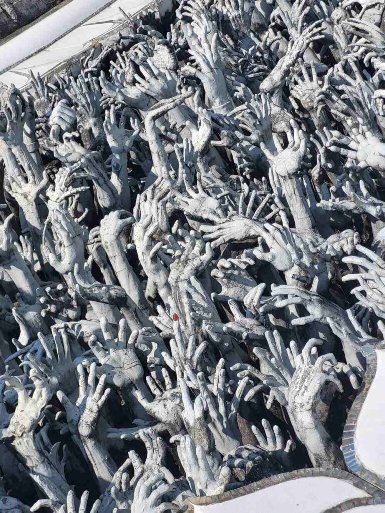The sea of hands that surrounds the walkway when entering the White Temple in Chiang Rai